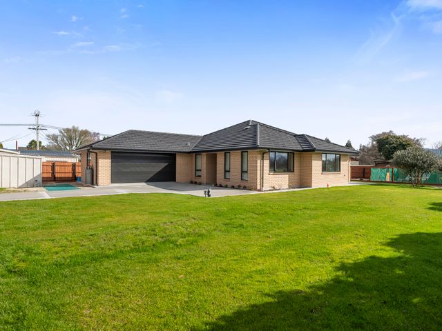 A house with a garage and lawn at Repatoa Holiday Home in Repatoa