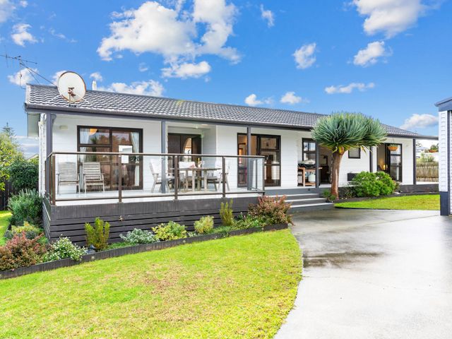 A house with a balcony and outdoor seating at Mangawhai Heads in Mangawhai