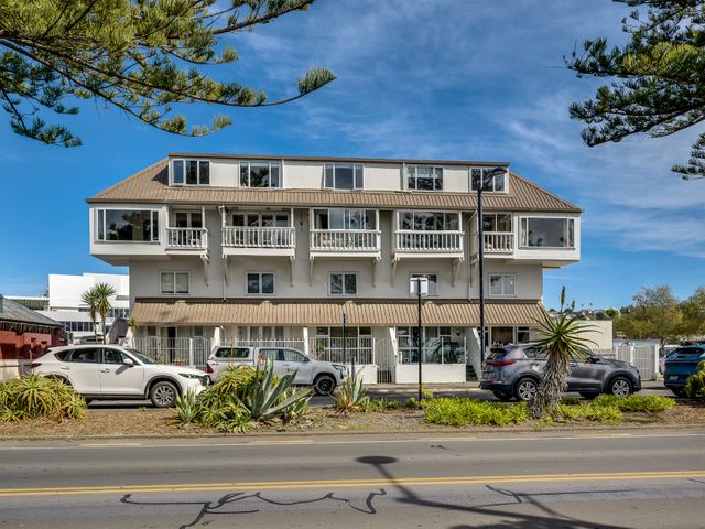 A building with balconies and vehicles parked at Sea-renity - Napier Holiday Home in Napier South