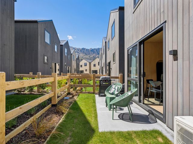 An outdoor area with chairs and a barbecue grill at Pinnacle Peaks - Queenstown Holiday Home in Queenstown