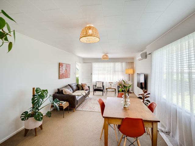 A living room with a sofa and dining table at Havelock North Holiday Home