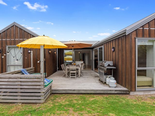 An outdoor area with a wooden deck and furniture at White Sands Haven - Omaha
