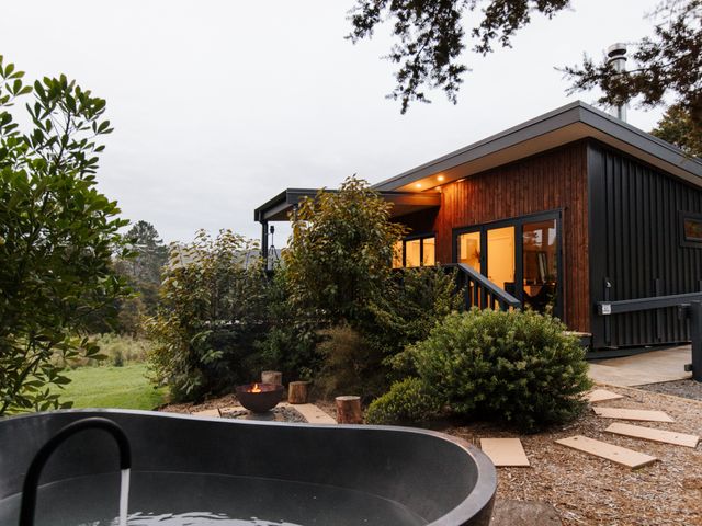 An outdoor area with a bathtub and fire pit at Hidden Springs Mountain View Waihi