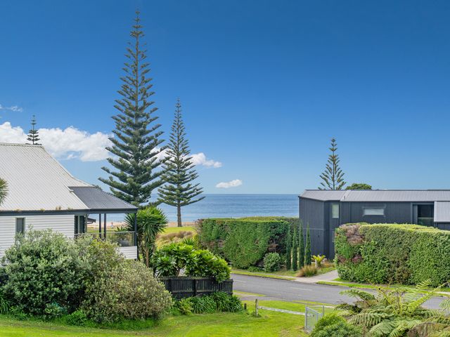 A view of houses and trees with the sea in the background at Whangamata