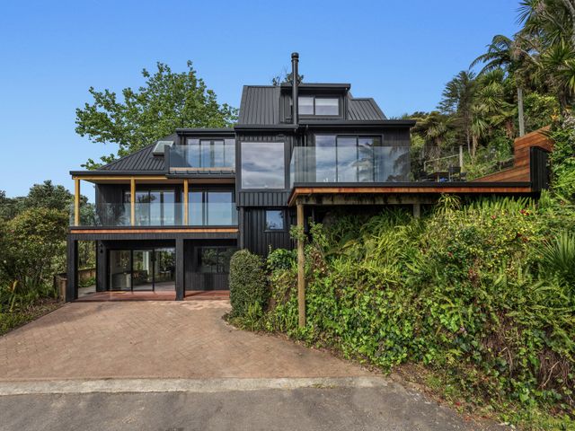 A house with a balcony and glass windows at Ohope Holiday home Ohope