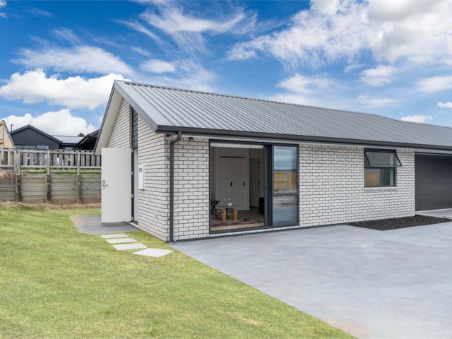 An outdoor view of a house with a pathway and grass at Wharewaka Vista - Taupo Holiday Home Taupo