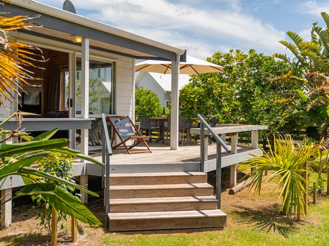An outdoor deck area with steps and seating at Sea Breezes - Matarangi Holiday Home in Whitianga