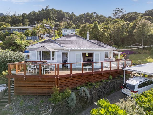A house with a deck and car in the outdoor area at Coromandel