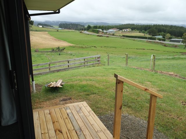 An outdoor area with decking and a fire pit at Moeraki Holiday Home Moeraki