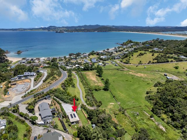 An aerial view of coastal area with houses and fields at Tutukaka in Whangarei