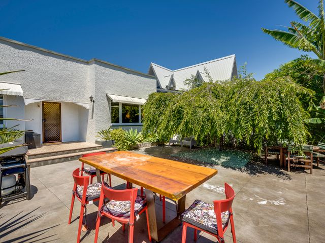 An outdoor dining area with a table and chairs at Deco-licious - Napier Holiday Home in Napier