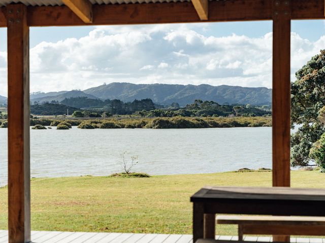 A view of water and mountains from a wooden structure at Mangawhai Heads