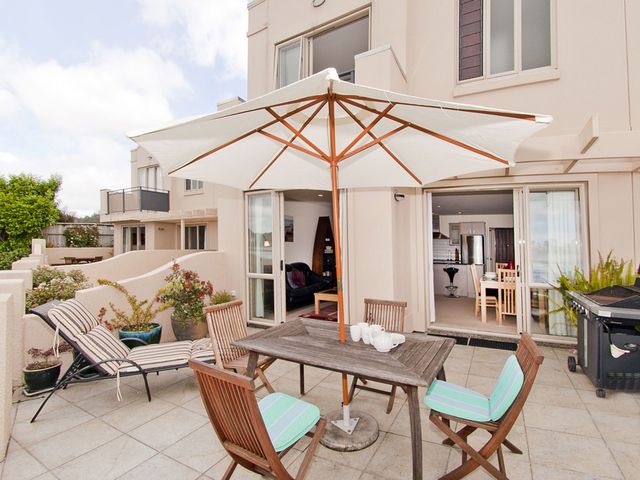 An outdoor patio with a table and chairs at Tairua Holiday Home in Tairua
