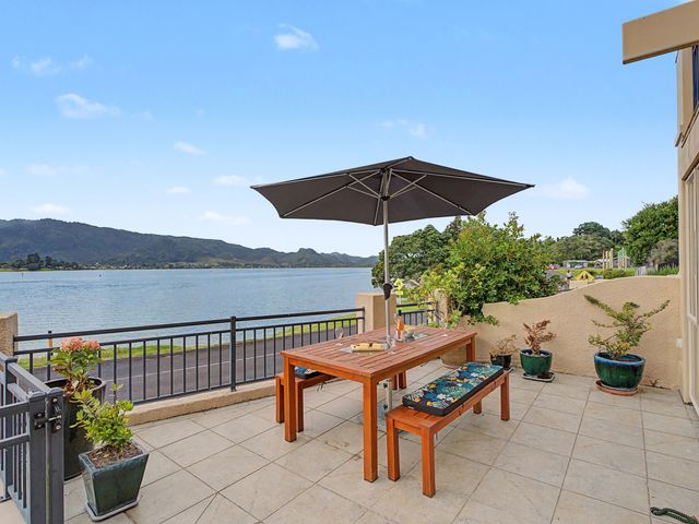 An outdoor area with a table and umbrella at Waterfront Bliss - Tairua Holiday Home, Tairua