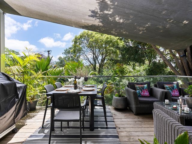 An outdoor patio with a dining table and seating at The Bridge Bird Sanctuary - Auckland