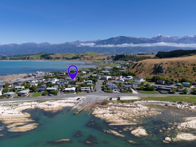 An aerial view of a coastal area with houses and mountains at The Bach - Kaikoura Holiday Home Kaikoura