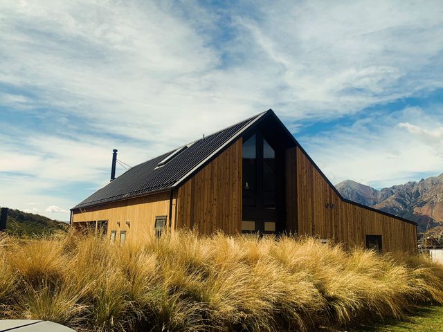 A house with grass in front and mountains in the background at Cedarwood Retreat - Castle Hill