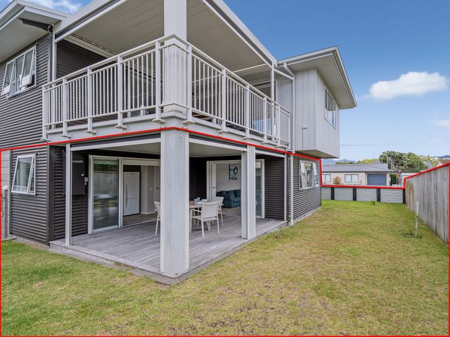 An outdoor patio with a table and chairs at Whangamata Holiday Unit in Whangamata