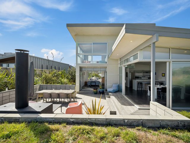 A house with a patio and dining area at Peka Peka Beach House - Waikanae