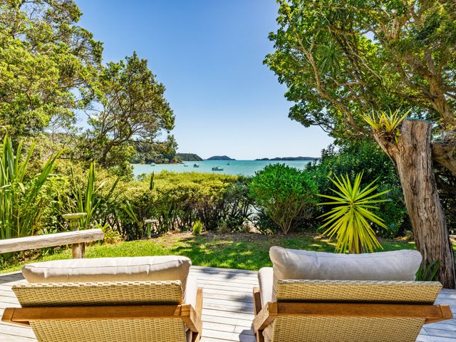 A deck with lounge chairs overlooking the water at Parekura Bay in Hikurangi