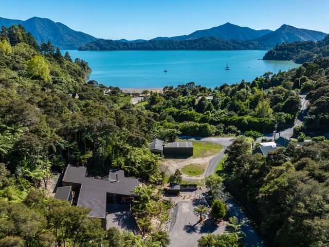 An aerial view of a house surrounded by trees and mountains at Nature's Luxe - Moetapu Bay Holiday Home Picton
