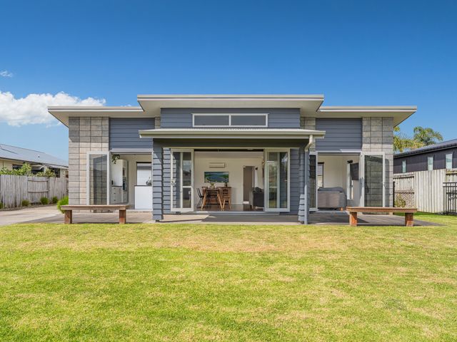 A house with a porch and benches at Sweet As on Aquila - Whitianga Holiday Home Whitianga