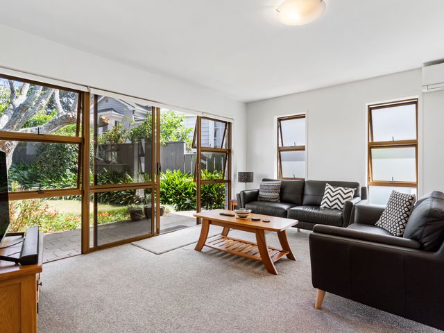 A living room with a sofa and coffee table at Moana - Onehunga Holiday Home in Auckland