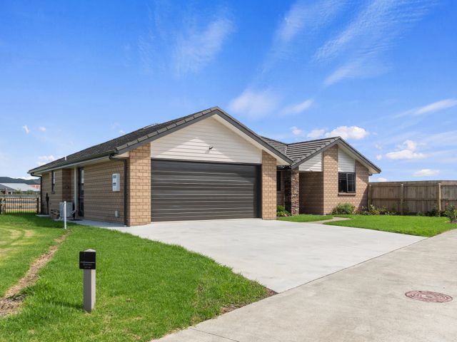 An exterior view of a house with a garage and driveway at Riverside Retreat - Waipu