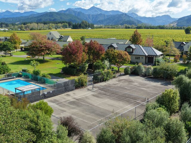 An outdoor area with a swimming pool and tennis court at Vintners - Renwick Holiday Home, Blenheim