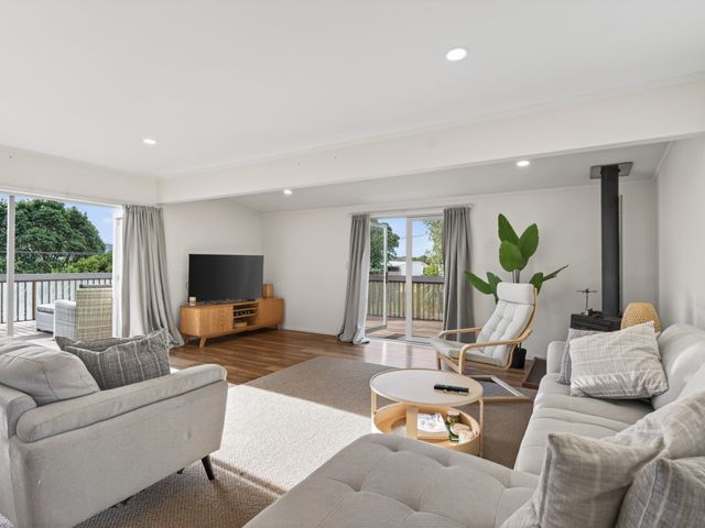 A living room with a sofa and television at Sundowners - Mangawhai Heads Holiday Home Mangawhai