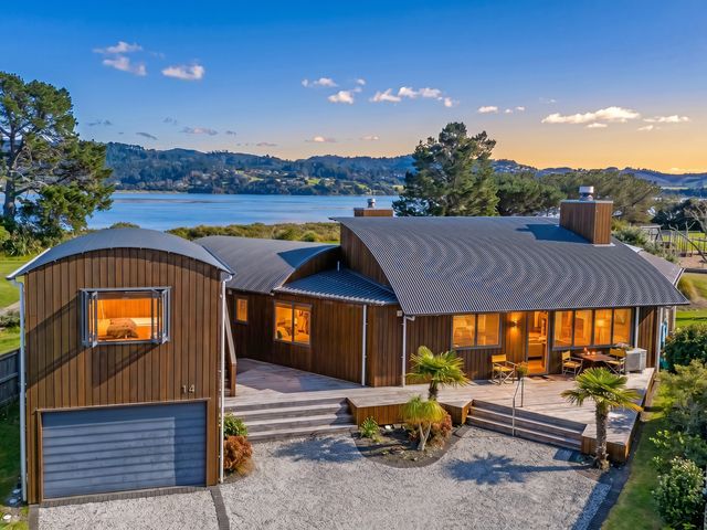 A house with a deck and garage at Ocean Breeze Family Haven - Pauanui