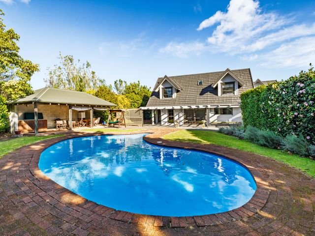 A swimming pool and house in the garden at Hawkings Lodge - Kerikeri Holiday home