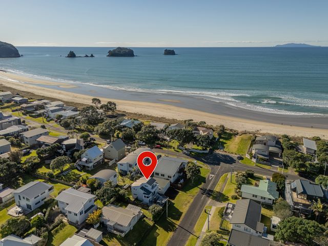 An aerial view of houses by the beach at Whangamata Holiday Home in Whangamata
