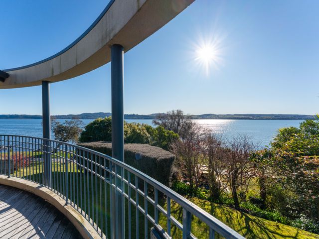 A view from a balcony overlooking the water at Rainbow Point Yacht Club - Taupo Holiday Home Taupo