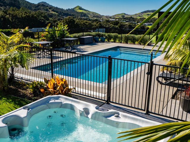 An outdoor area with a pool and hot tub at Mangawhai Holiday Home in Mangawhai
