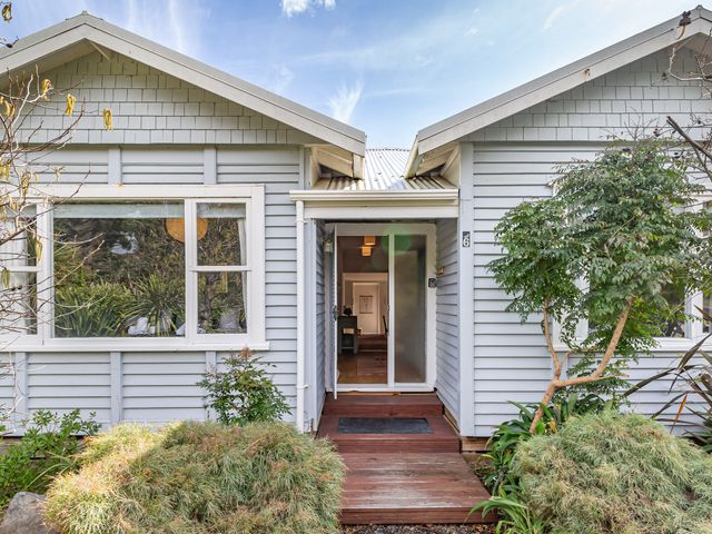 An entrance to a house with plants and a pathway at Garden Grove - Kapiti Coast Holiday Home Kapiti Coast