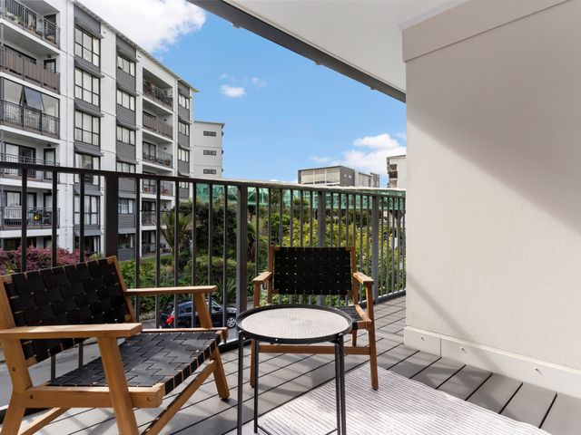 A balcony with chairs and a table at Westlight Apartment - Henderson Holiday Home, Auckland