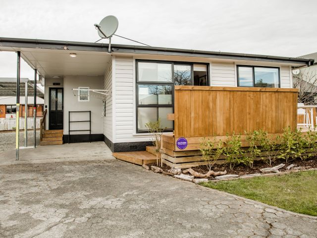A house with a wooden deck and satellite dish at Southern Base - Te Anau Holiday Home in Te Anau