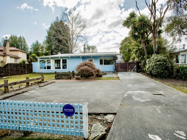 A house with a fence and driveway at Little Blue House - Te Anau
