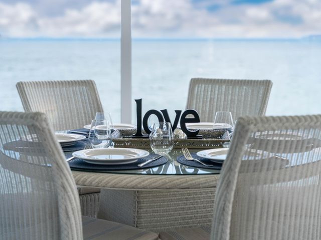 A dining table with settings and a decorative sign at Hampton Cottage by the Lake - Taupo Central