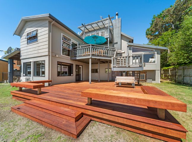 A house with a large wooden deck and stairs in a backyard at Choice Wharewaka - Taupo Holiday Home Wharewaka