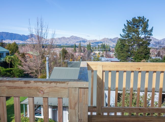 View of rooftops trees and mountains from a wooden balcony at Lofty Quarters - Hamner Springs Holiday Home in Hanmer Springs