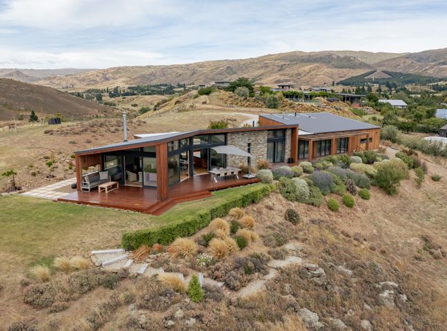 A house with a deck and garden at Vino and Views - Bannockburn Holiday Home Cromwell