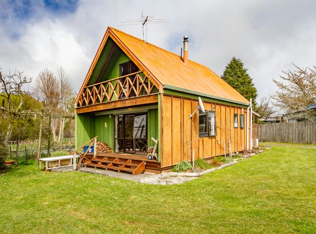 A wooden house with orange roof and green walls with a small porch and balcony at Green Gables - Raetihi Holiday Home in Raetihi