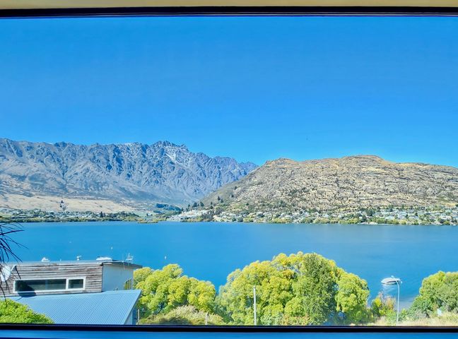 A view of mountains and a lake with trees and houses in the foreground at Picture Perfect - Queenstown Holiday Home Queenstown - Wanaka