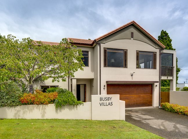 A modern two-story house with a garage and a front garden at Busby Hill Villa in Havelock North