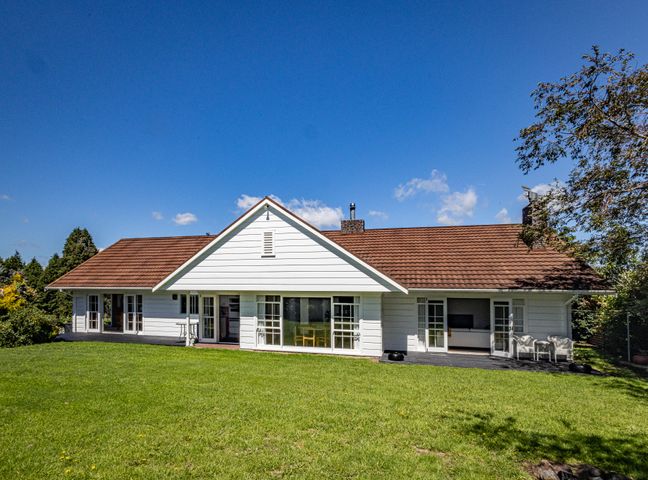 A single story house with white siding brown roof and green lawn at Grand Lodge - Ohakune Holiday Home in Ohakune