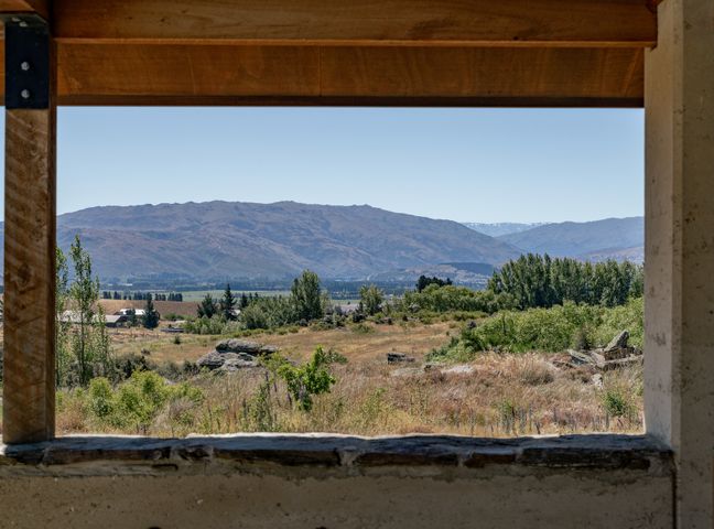 A landscape with trees bushes and mountains viewed through a window frame at A Place in Thyme - Alexandra Holiday Home in Alexandra