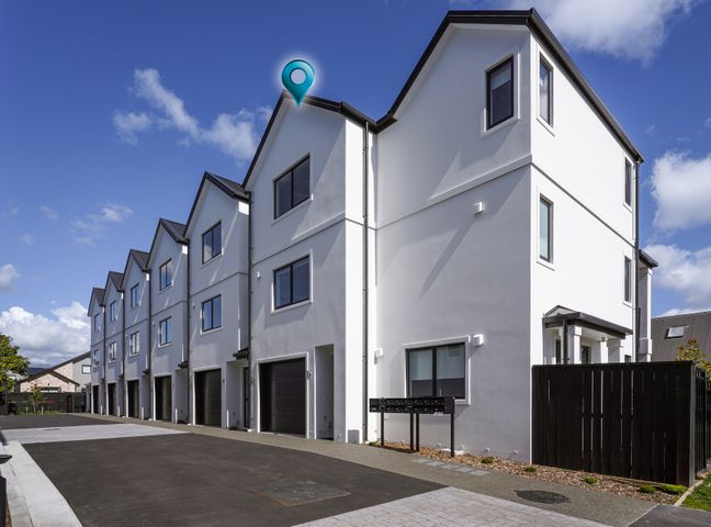 A row of white modern townhouses with garages and mailboxes at Modern Central Apartment - Christchurch Apartment in Monavale