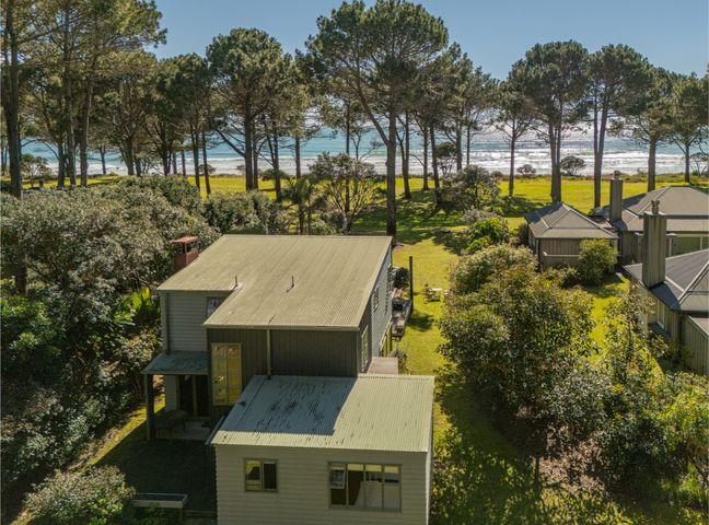An outdoor area with a house and trees near the beach at 